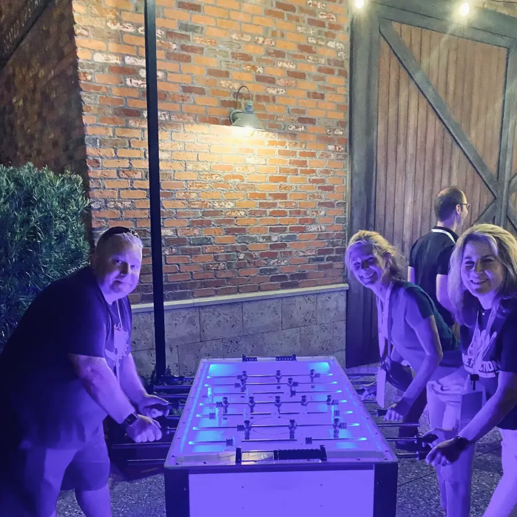 three people playing foosball