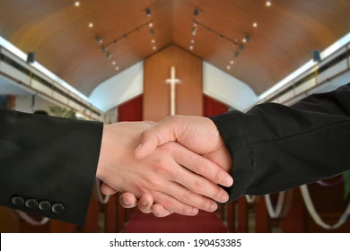 Two people shaking hands in front of a church altar with a cross